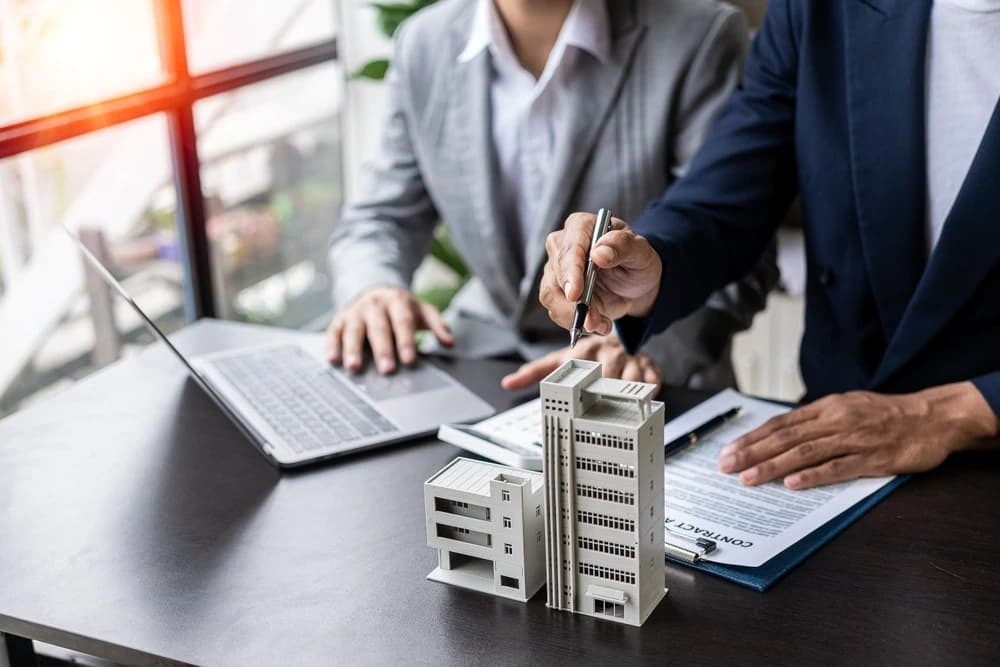 a real estate investor signing a document next to a commercial real estate