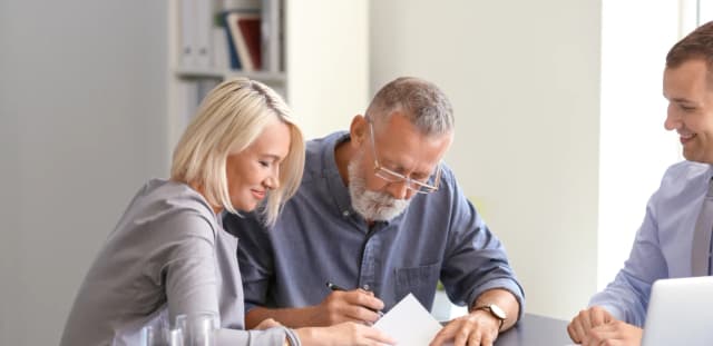 Senior couple signing financial planning agreement