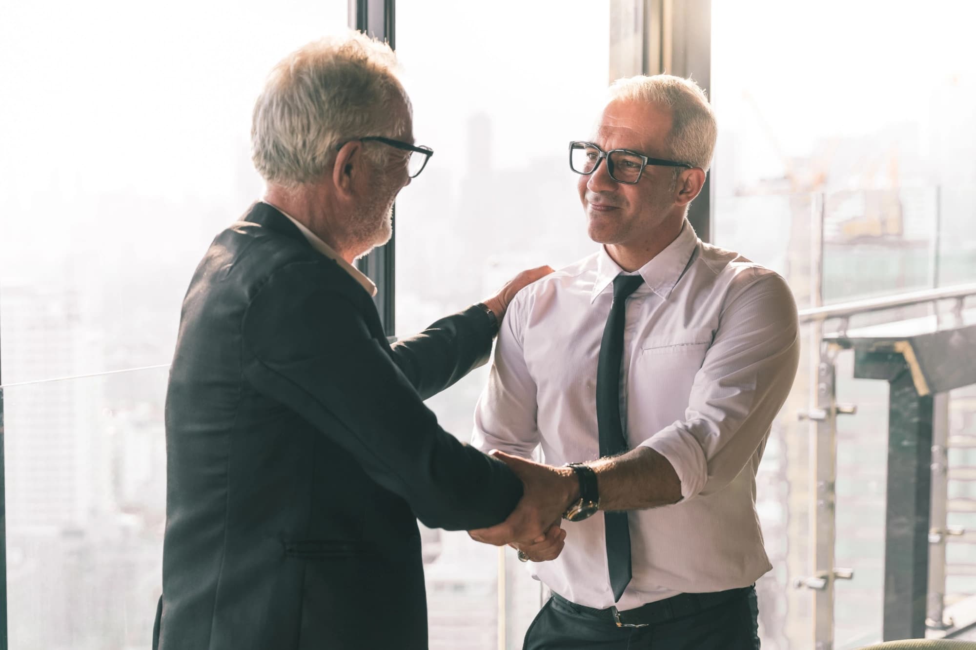 Older businessman shaking the hand of his successor