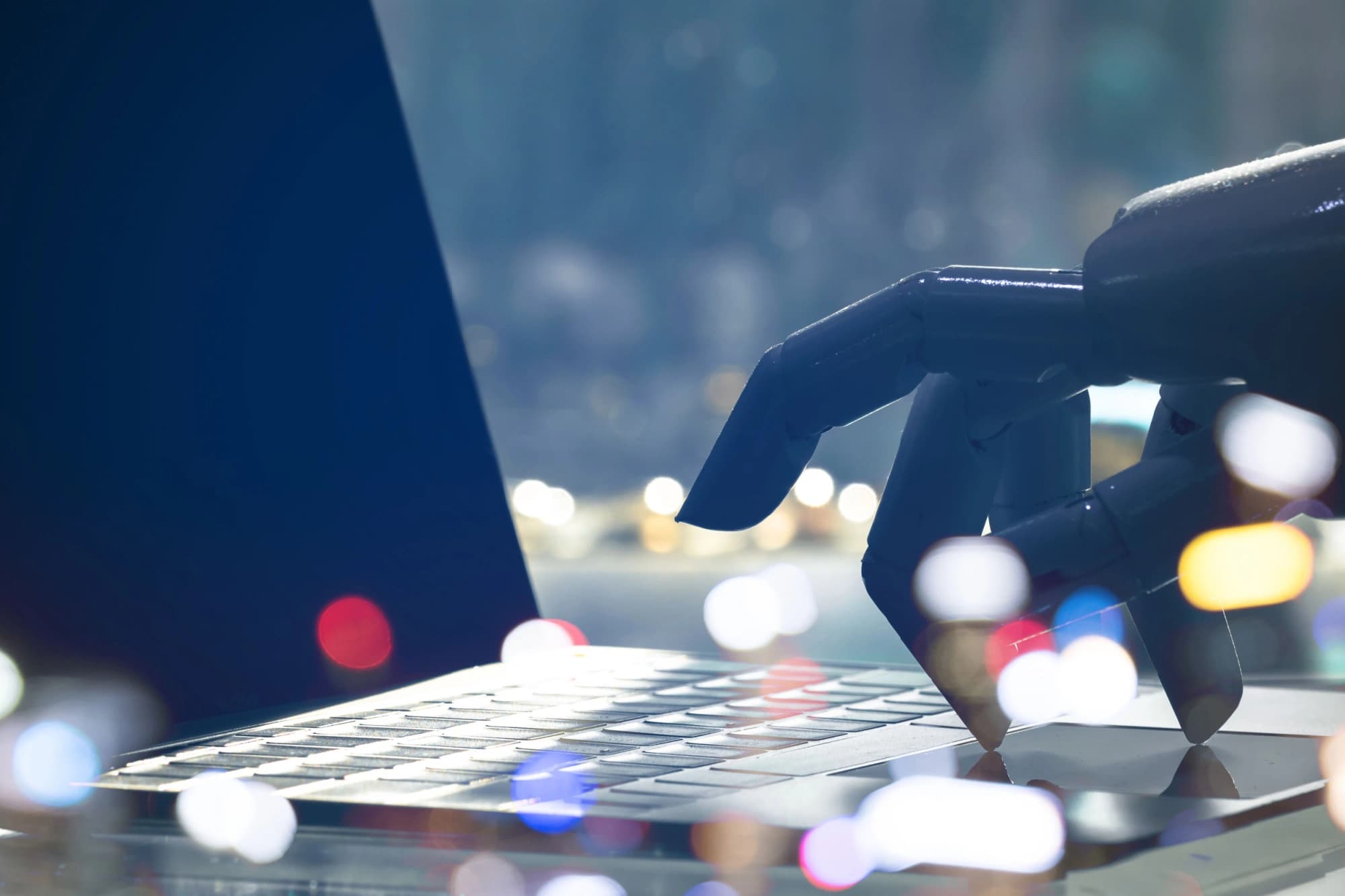 Robot hand typing on a laptop