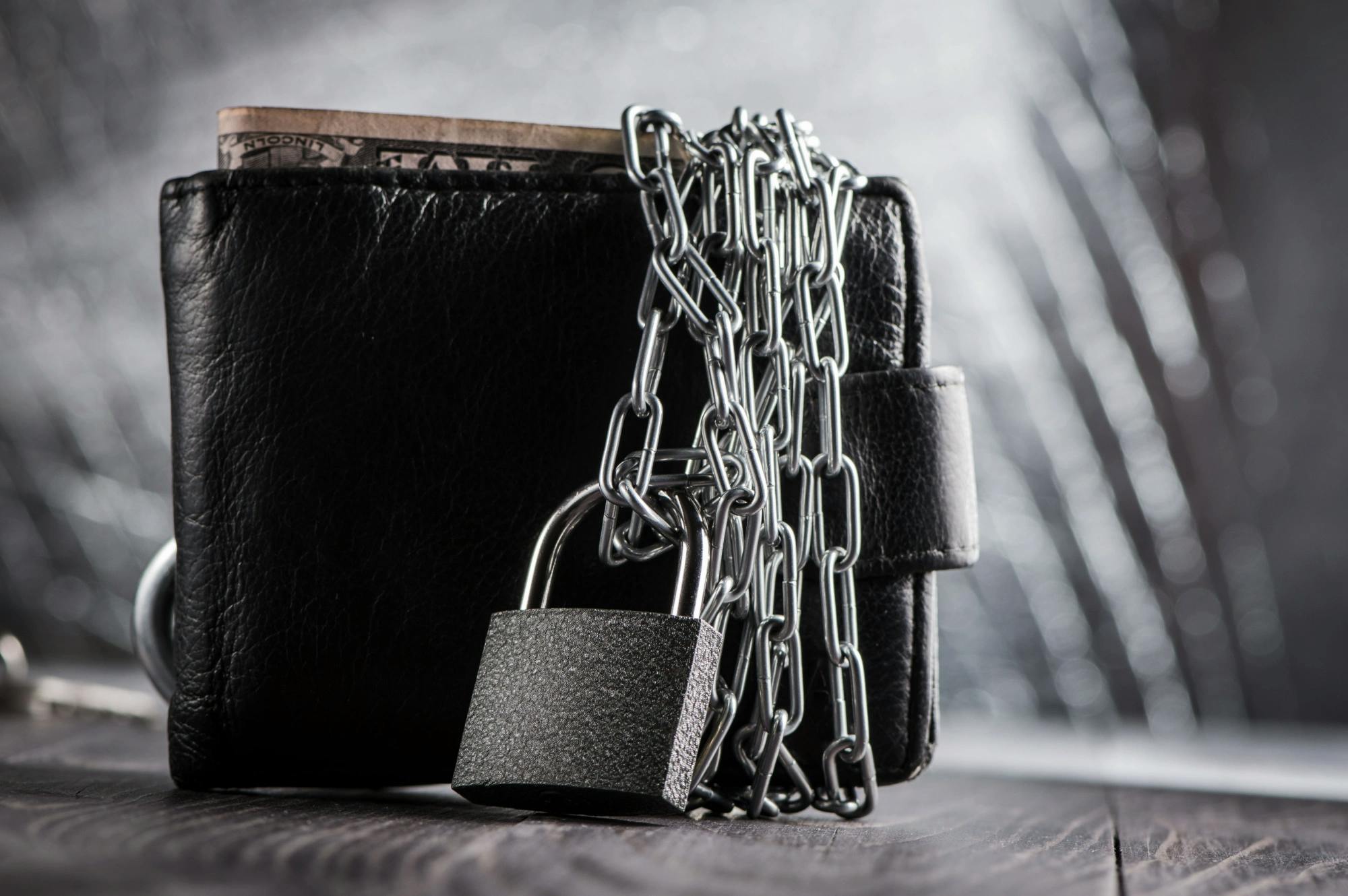 Lock and chain around a wallet protecting the money