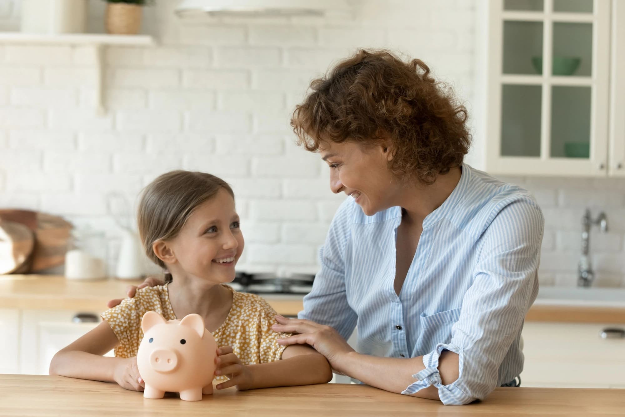 A mother and daughter with a piggy bank