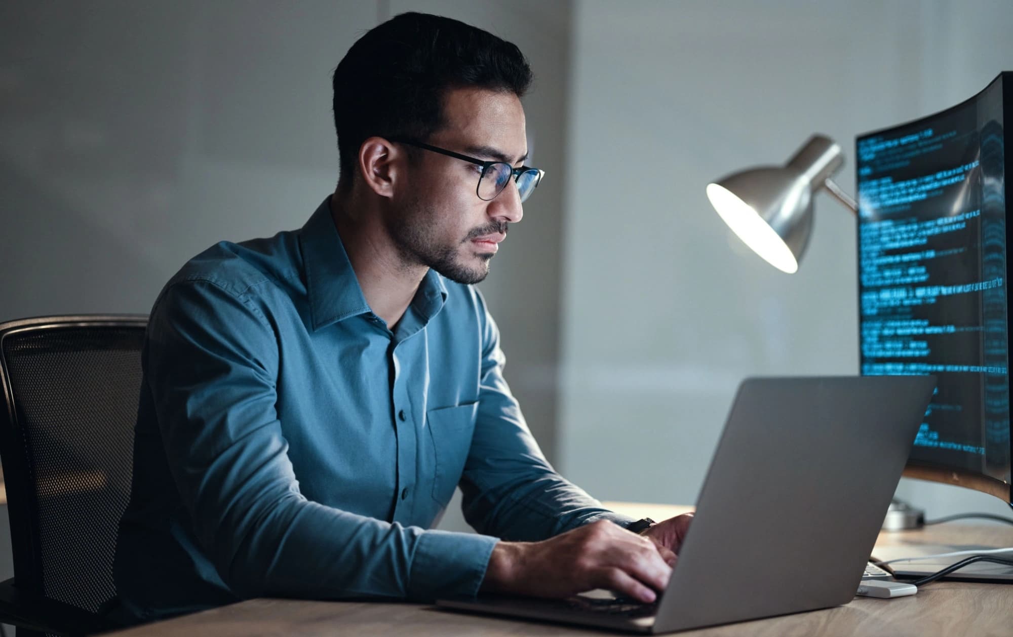 Man working on a laptop in his dark room