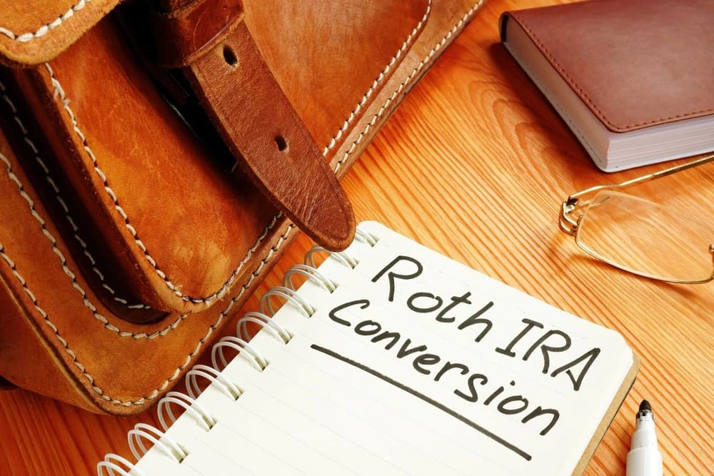 A notebook with the words “Roth IRA Conversion” on the page.