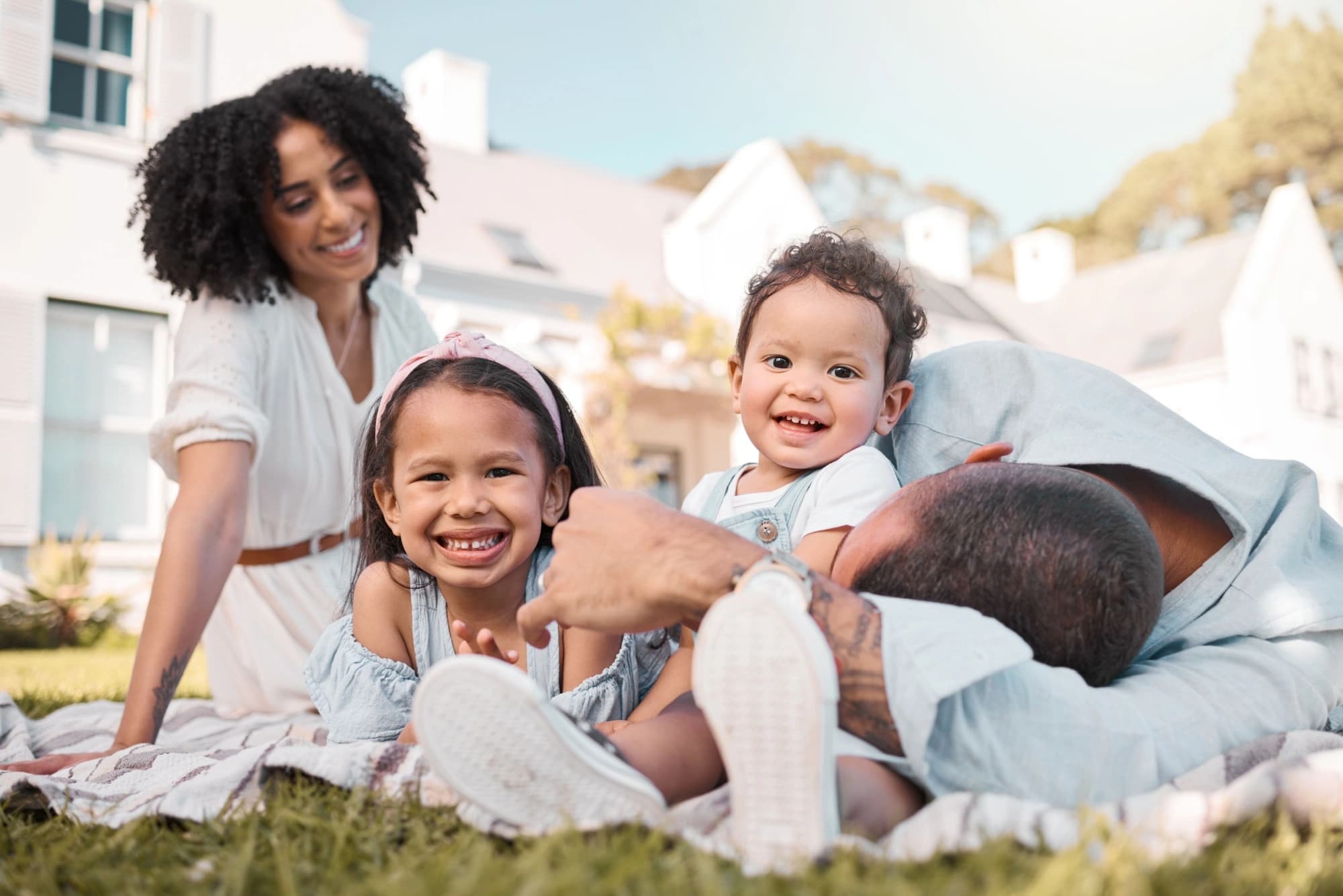 Blended family with two young children sitting on the lawn