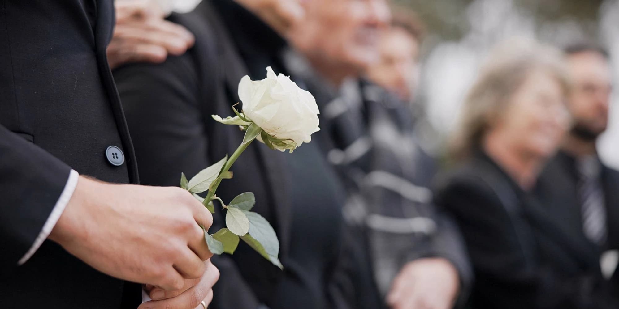 funeral attendees gathered at a grave