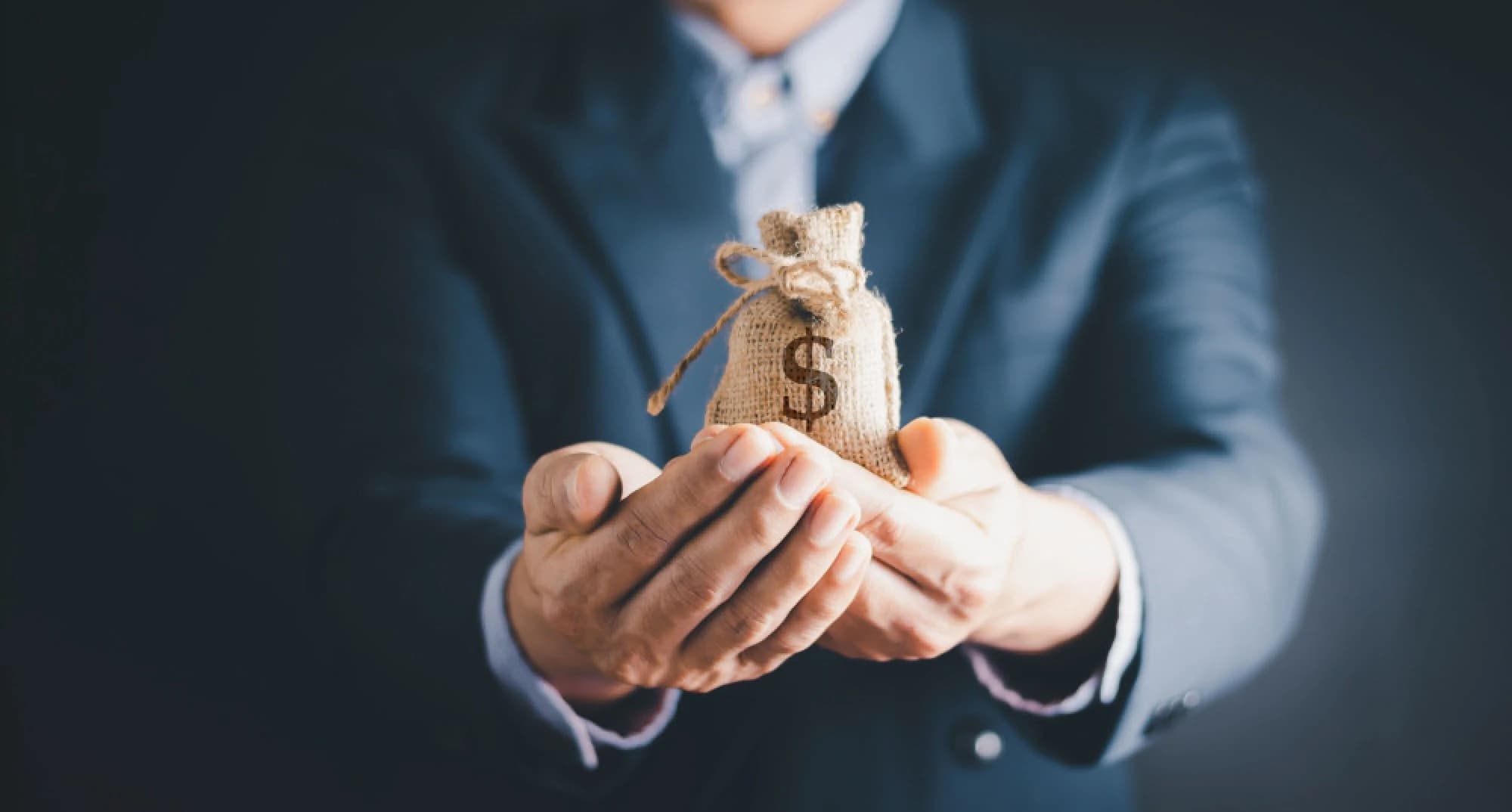 A benefactor holding out a bag full of money