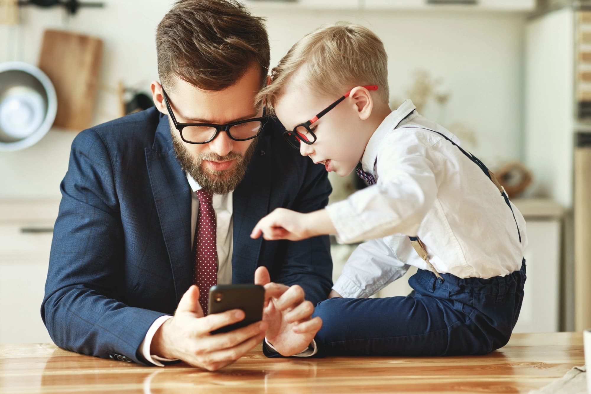 Wealthy dad showing his young son something on his phone