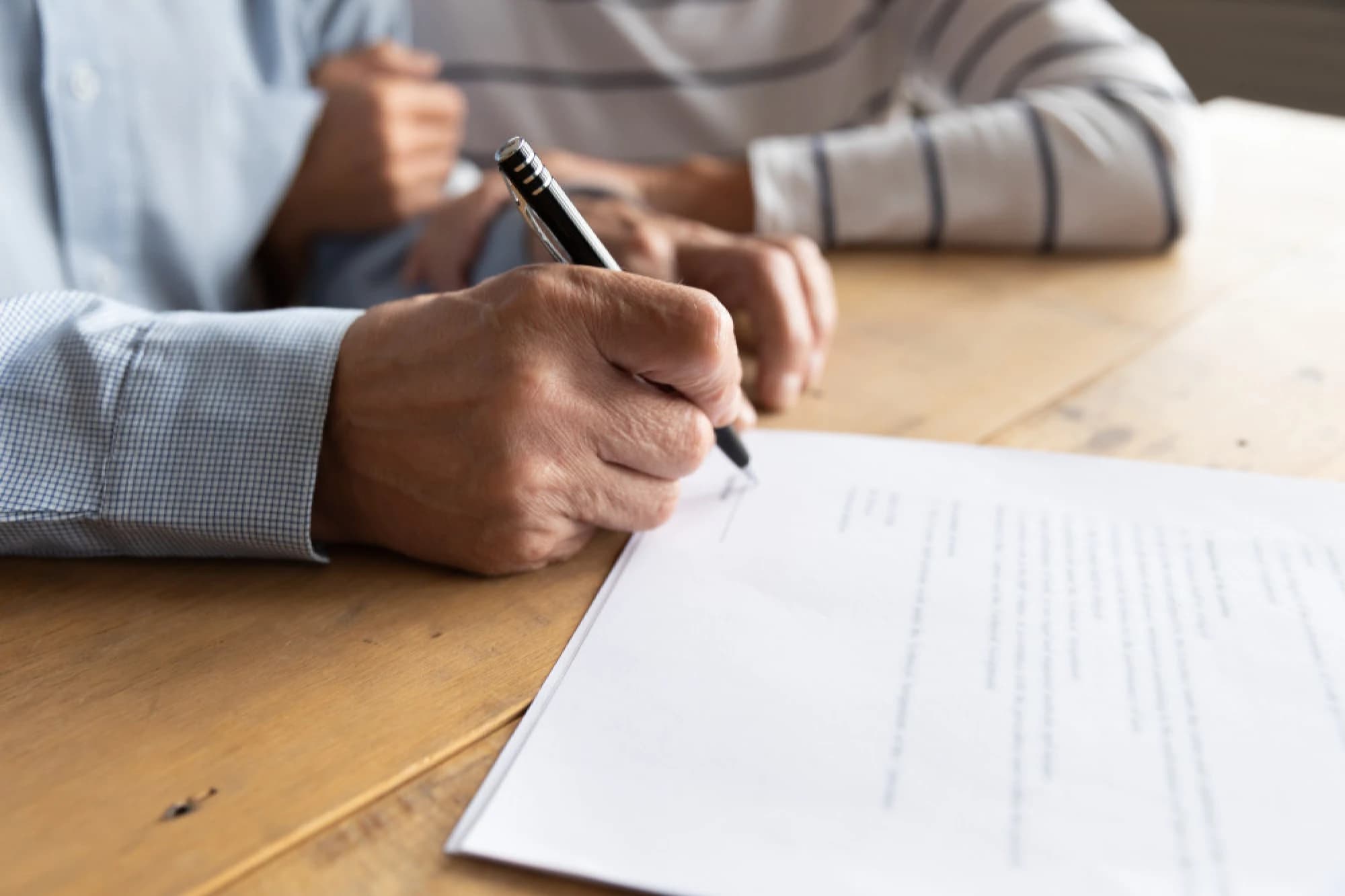 An UHNW couple signing estate planning paperwork for their trust.