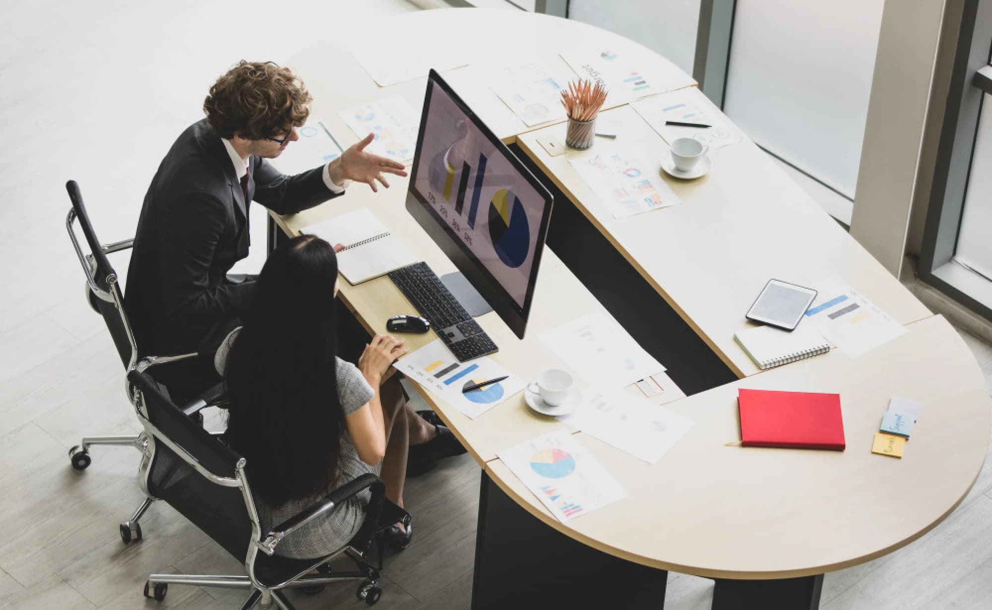 A wealth advisor reviewing an investment portfolio with his client