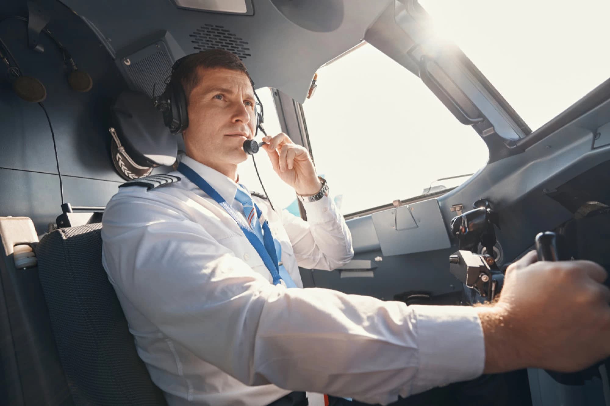 An commercial airline pilot in the cockpit of a plane