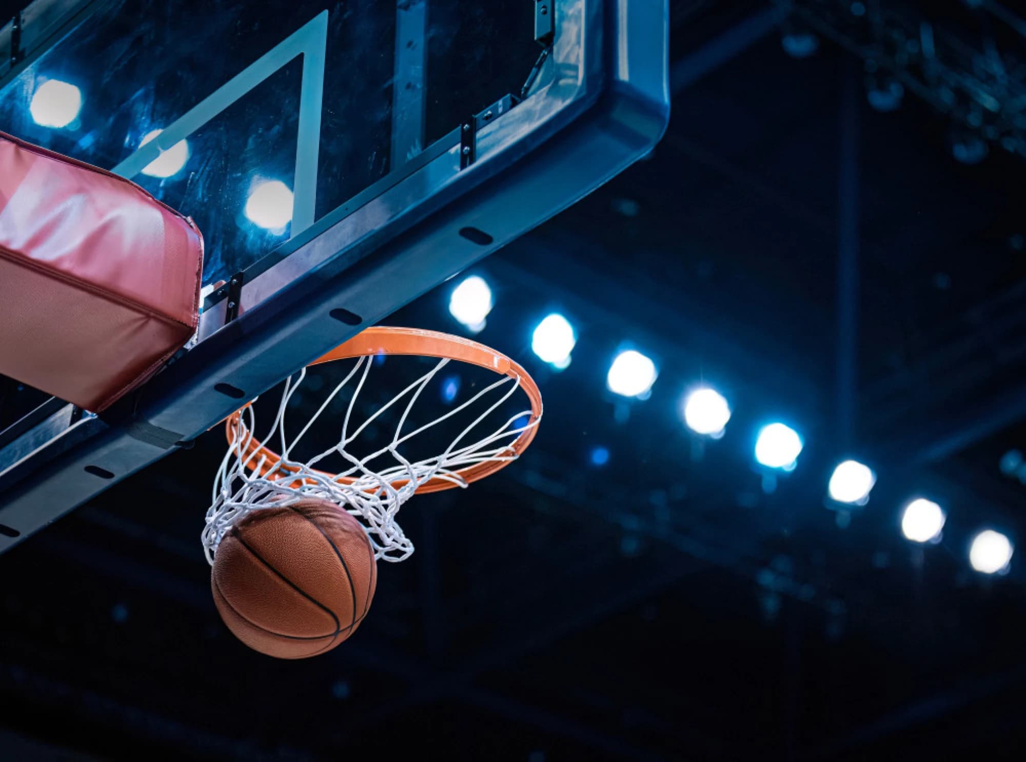 A basketball swishing through a net in a sports arena