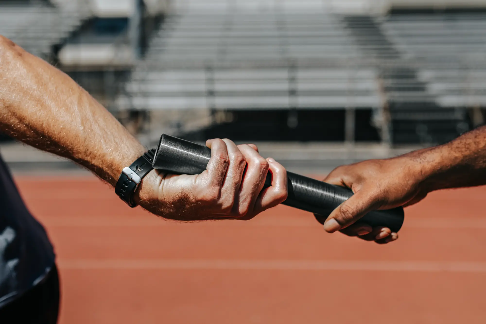teammates in a relay race passing a baton