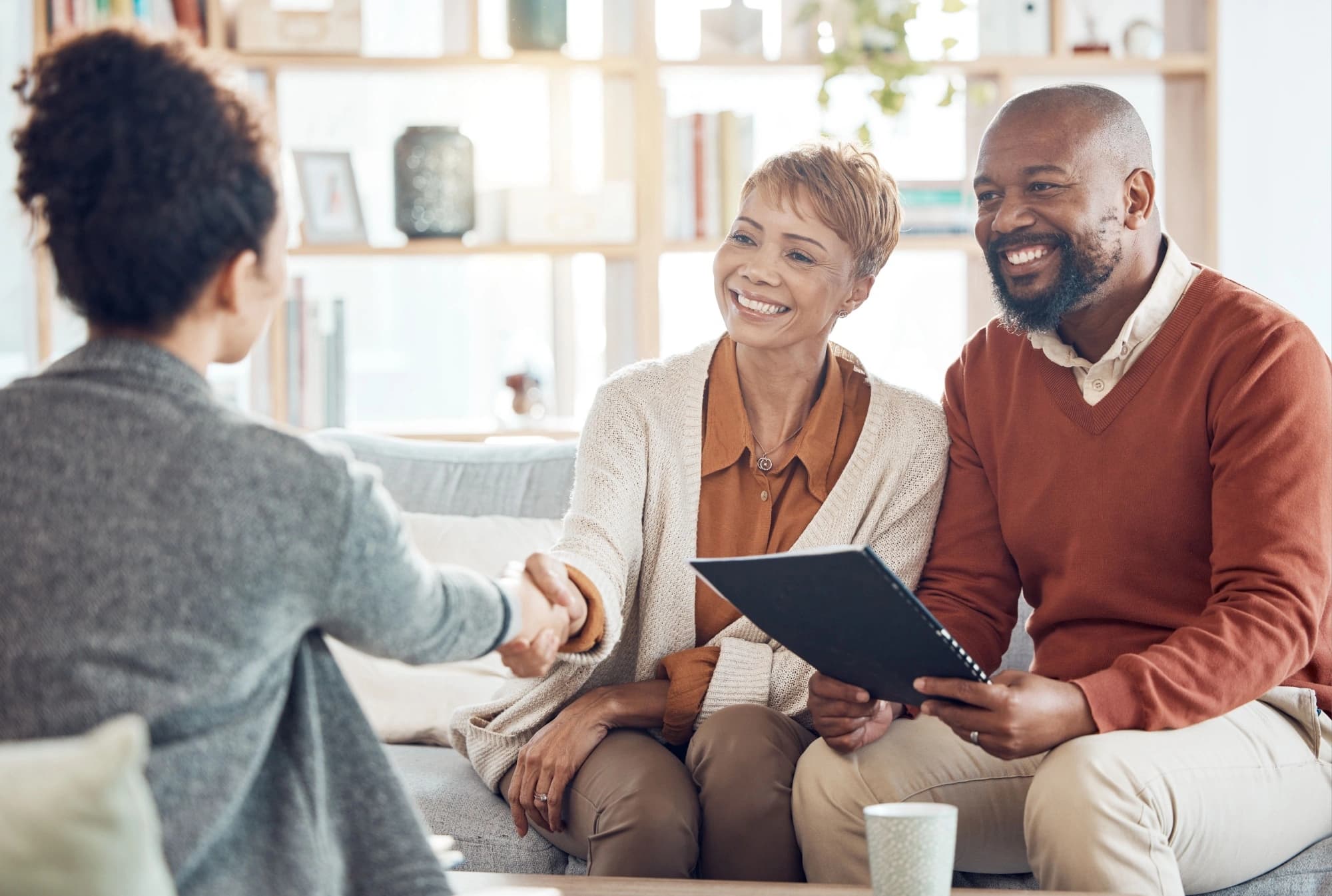 Older couple shaking hands with their retirement planner