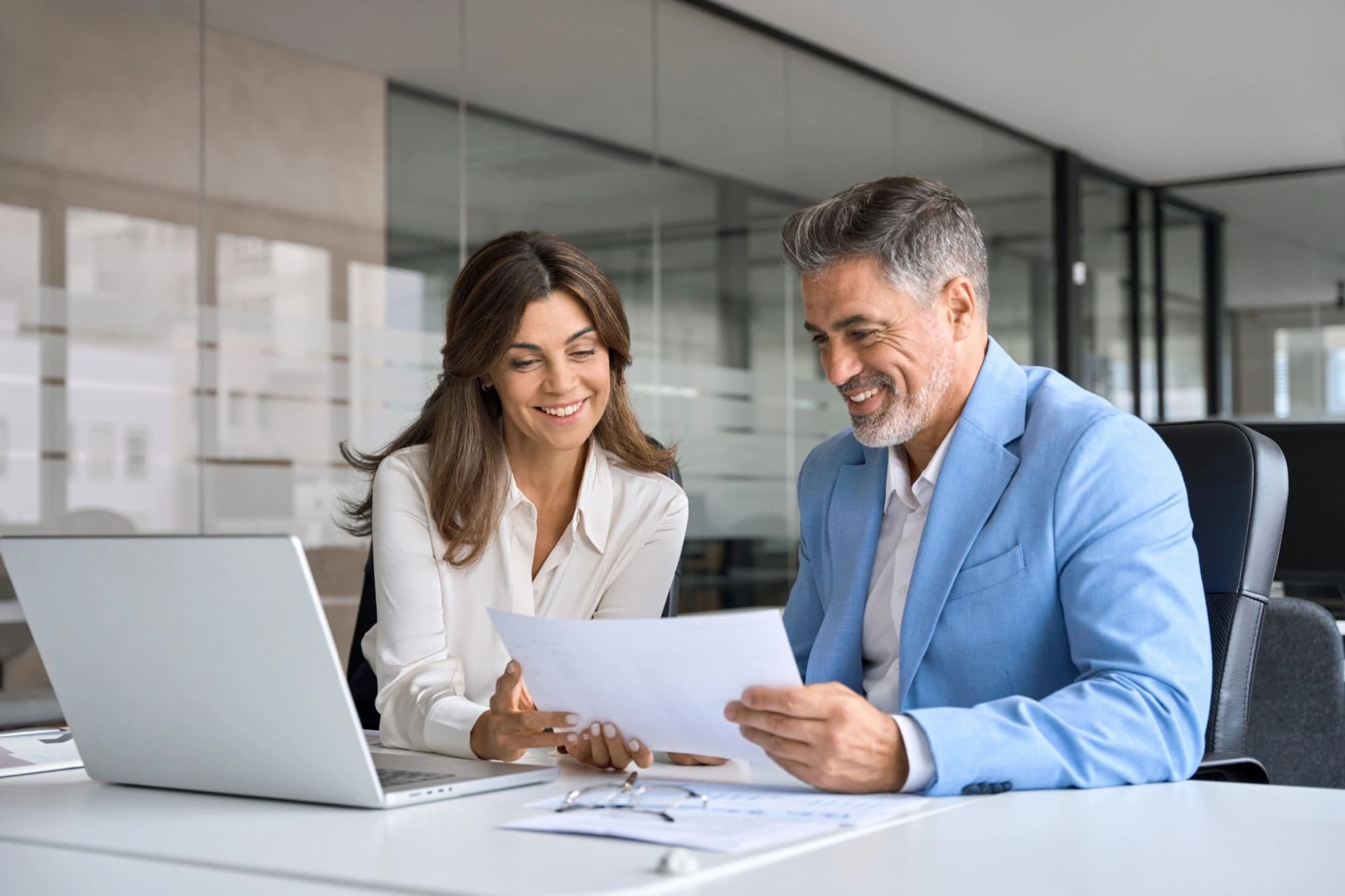 Two business people looking at opportunity zones on a laptop