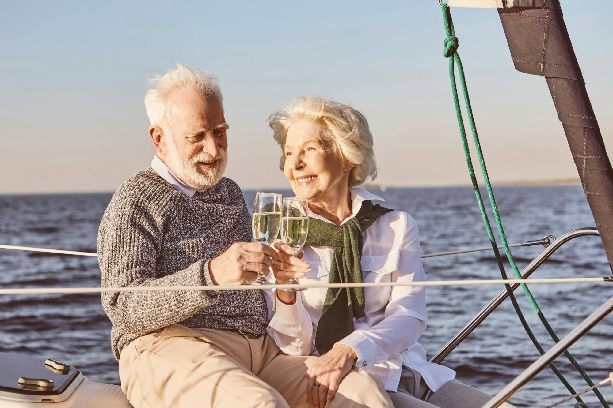 Wealthy elderly couple drinking wine on a boat
