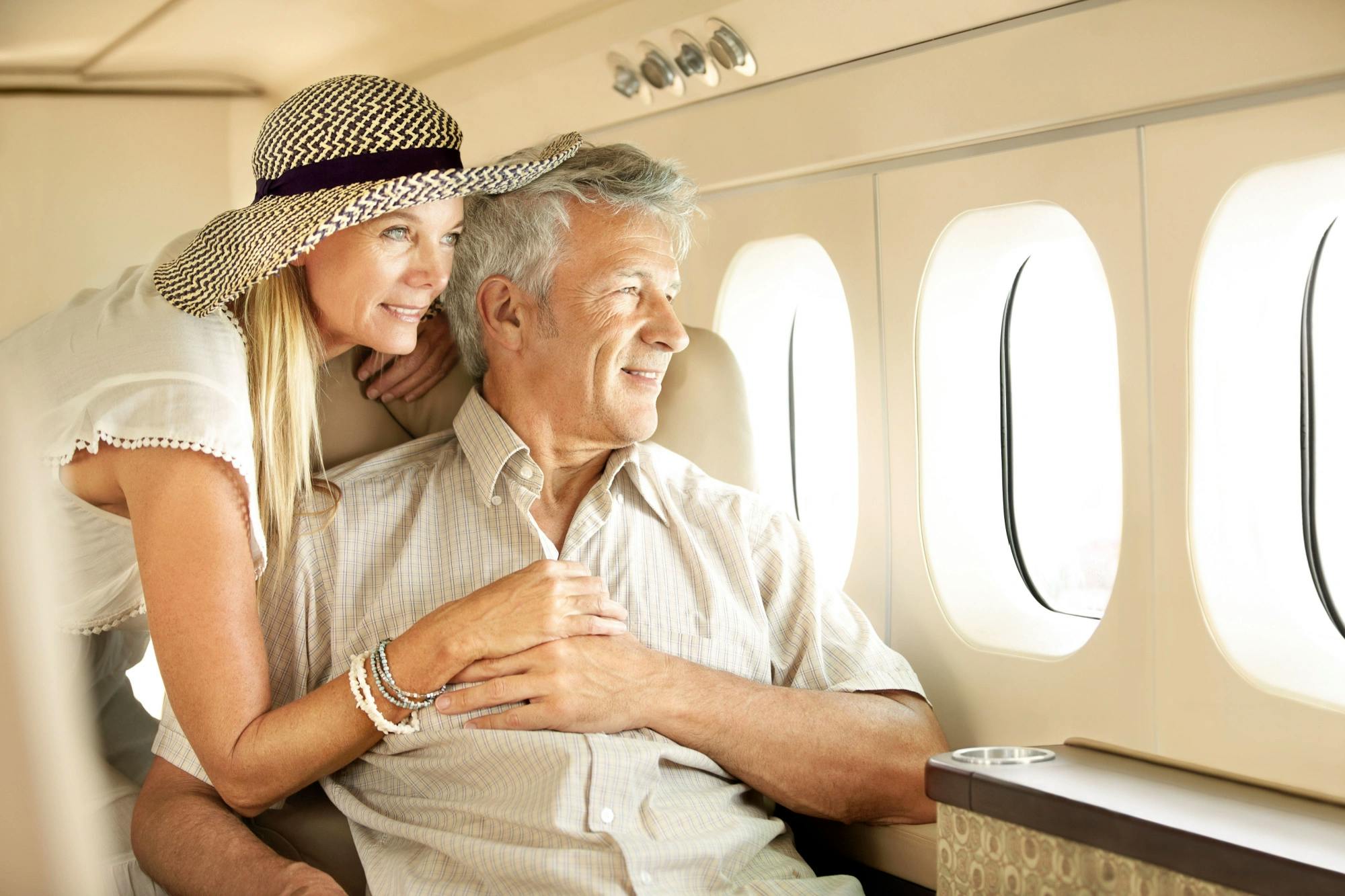 Wealthy older couple looking out the window of a private plane