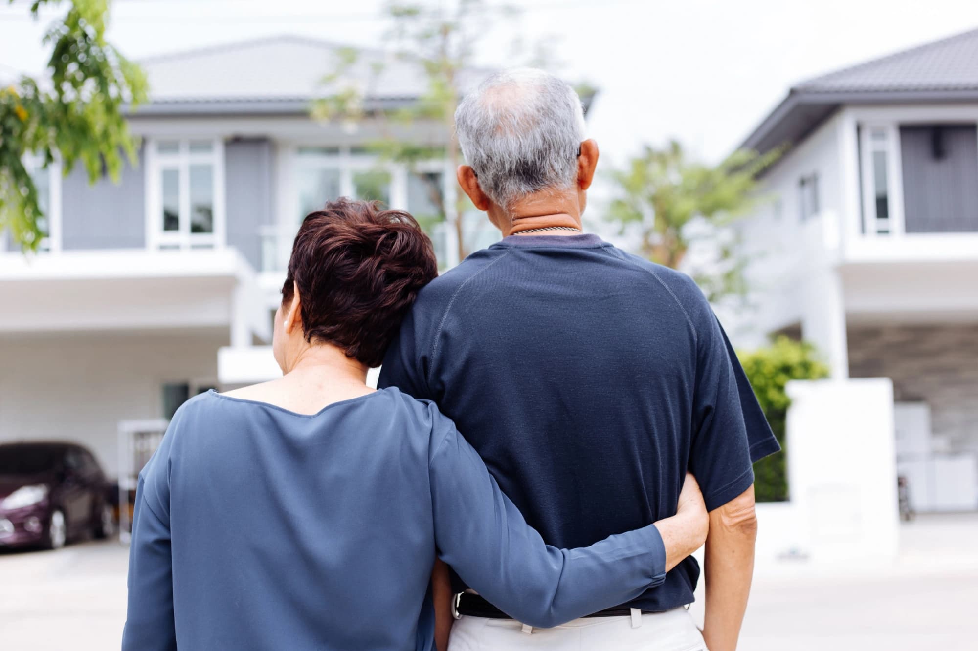 wealthy man and woman standing in front of the home they will transfer to their child in Texas