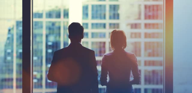 Couple looking through an office window