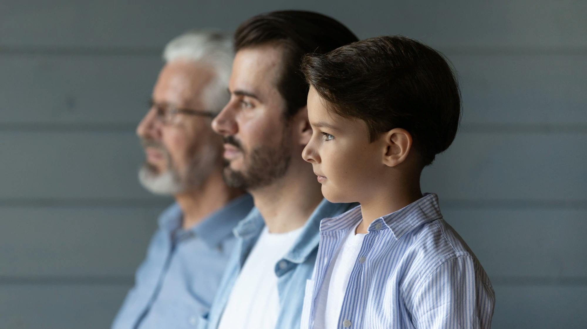 Three generations of men standing in a line.