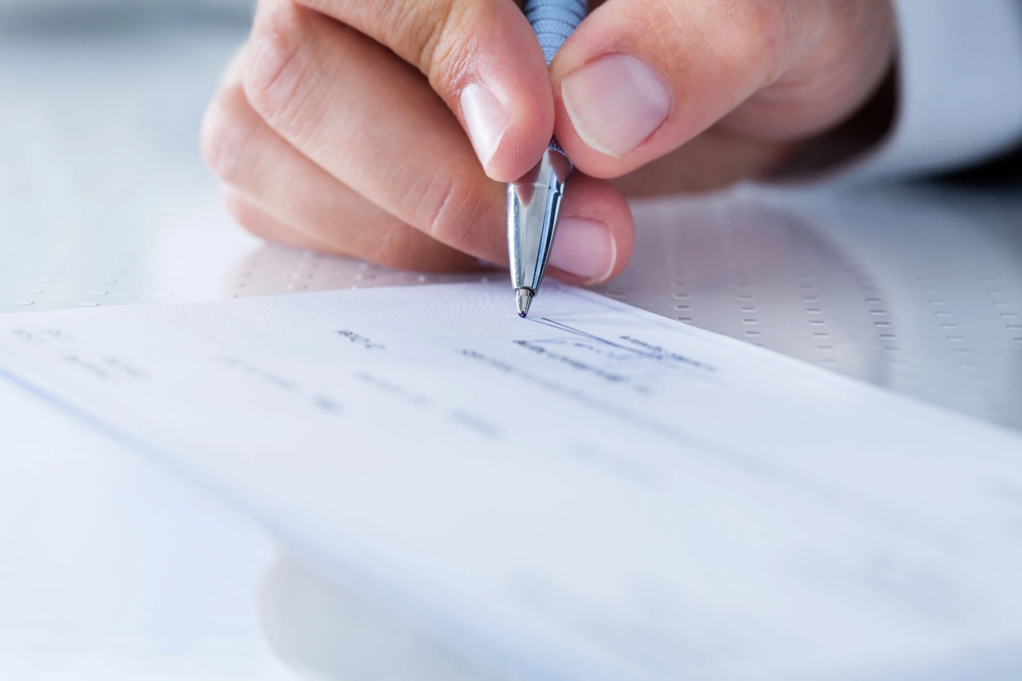 Male hand filling out a check