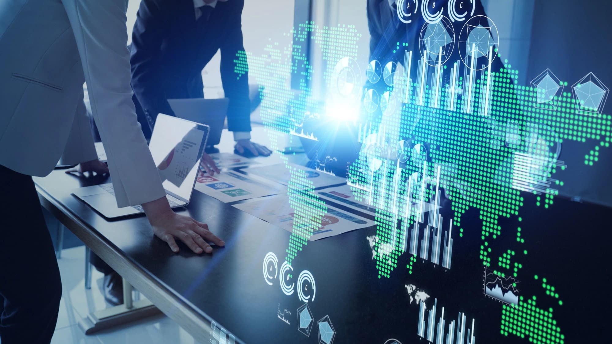 Businessman standing over a computer with global map overtop the image
