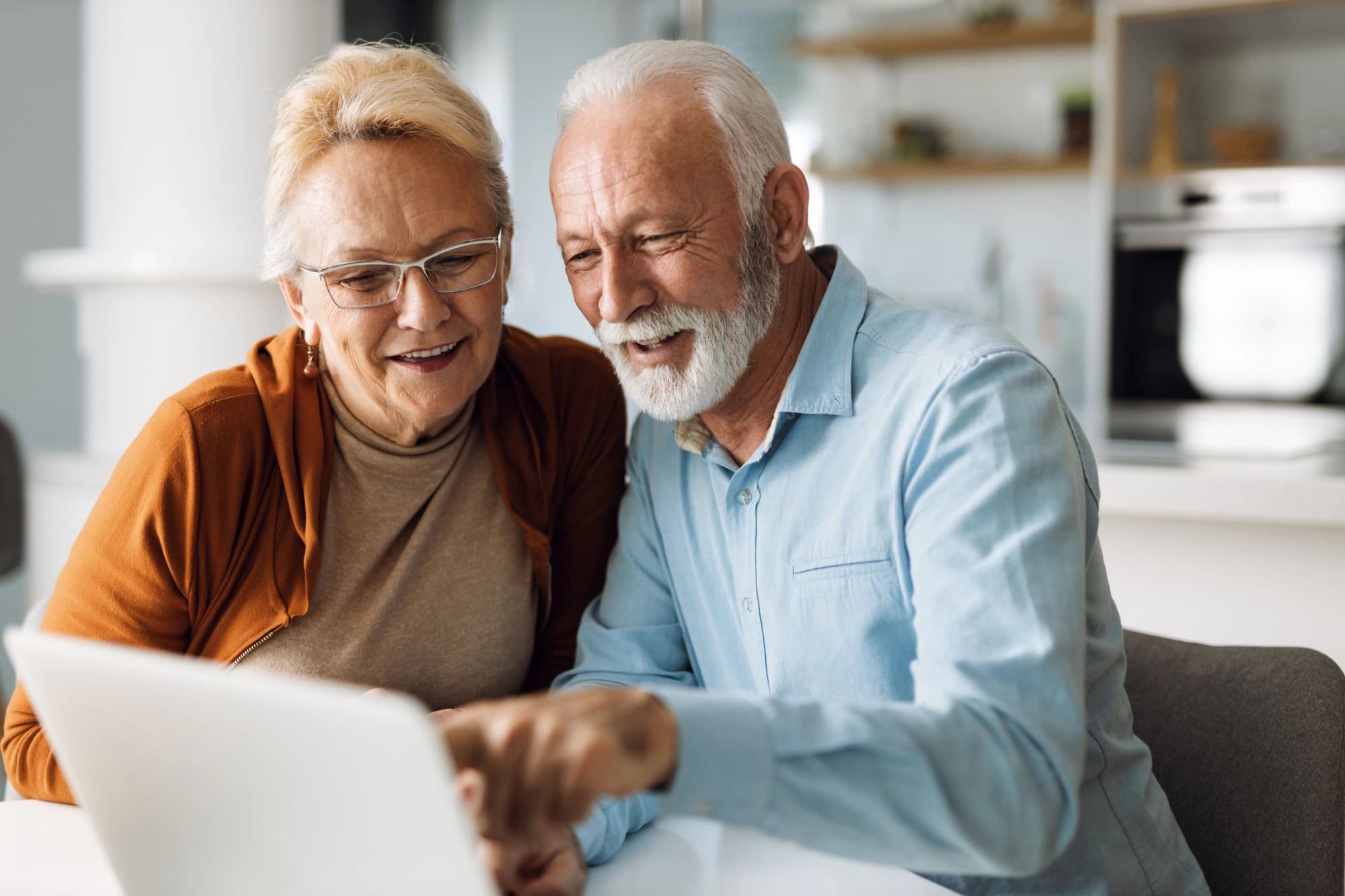 Retired couple looking up back door roth strategies on a laptop