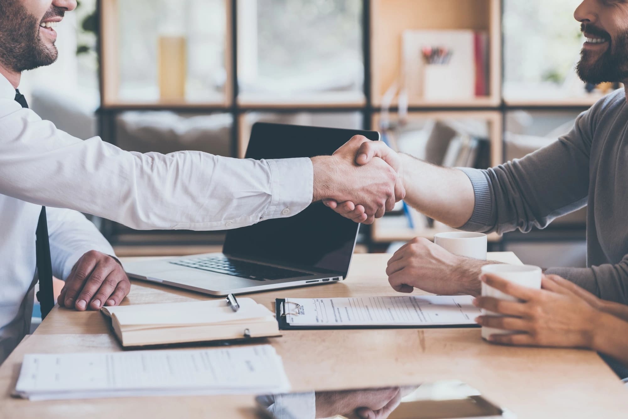 Two businessmen shaking hands after creating a buy-sell agreement