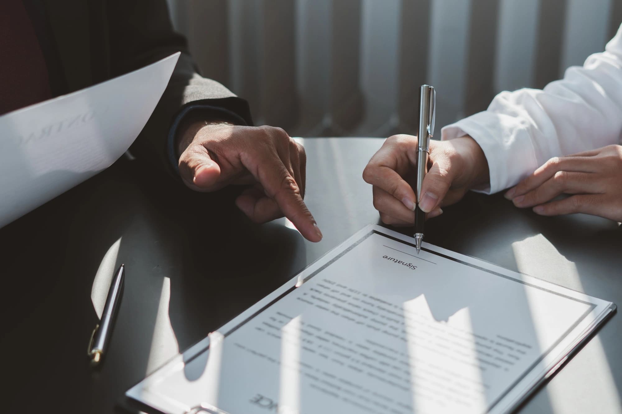 business people signing a business ownership transfer document