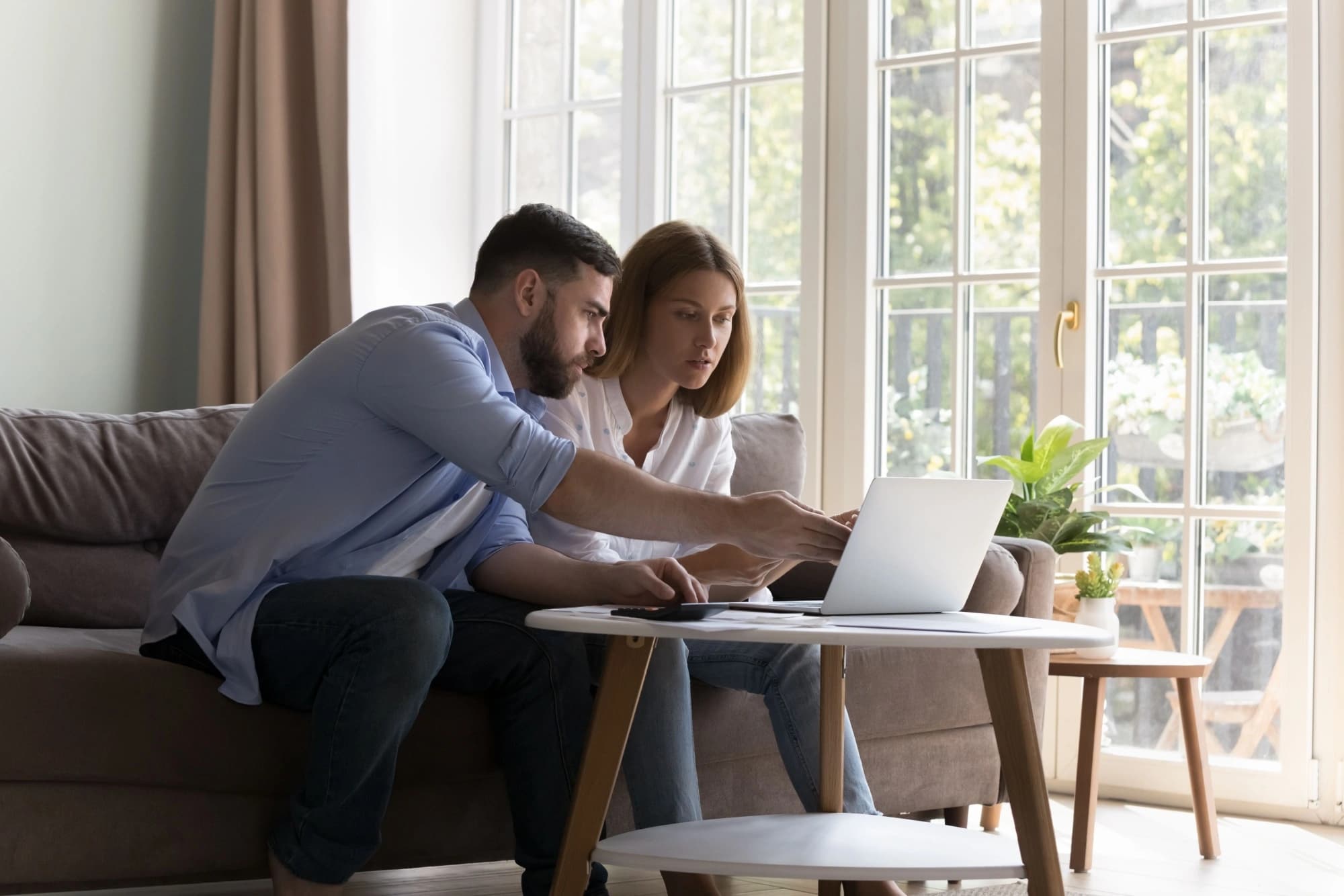 Young couple looking at a laptop, discussing their retirement