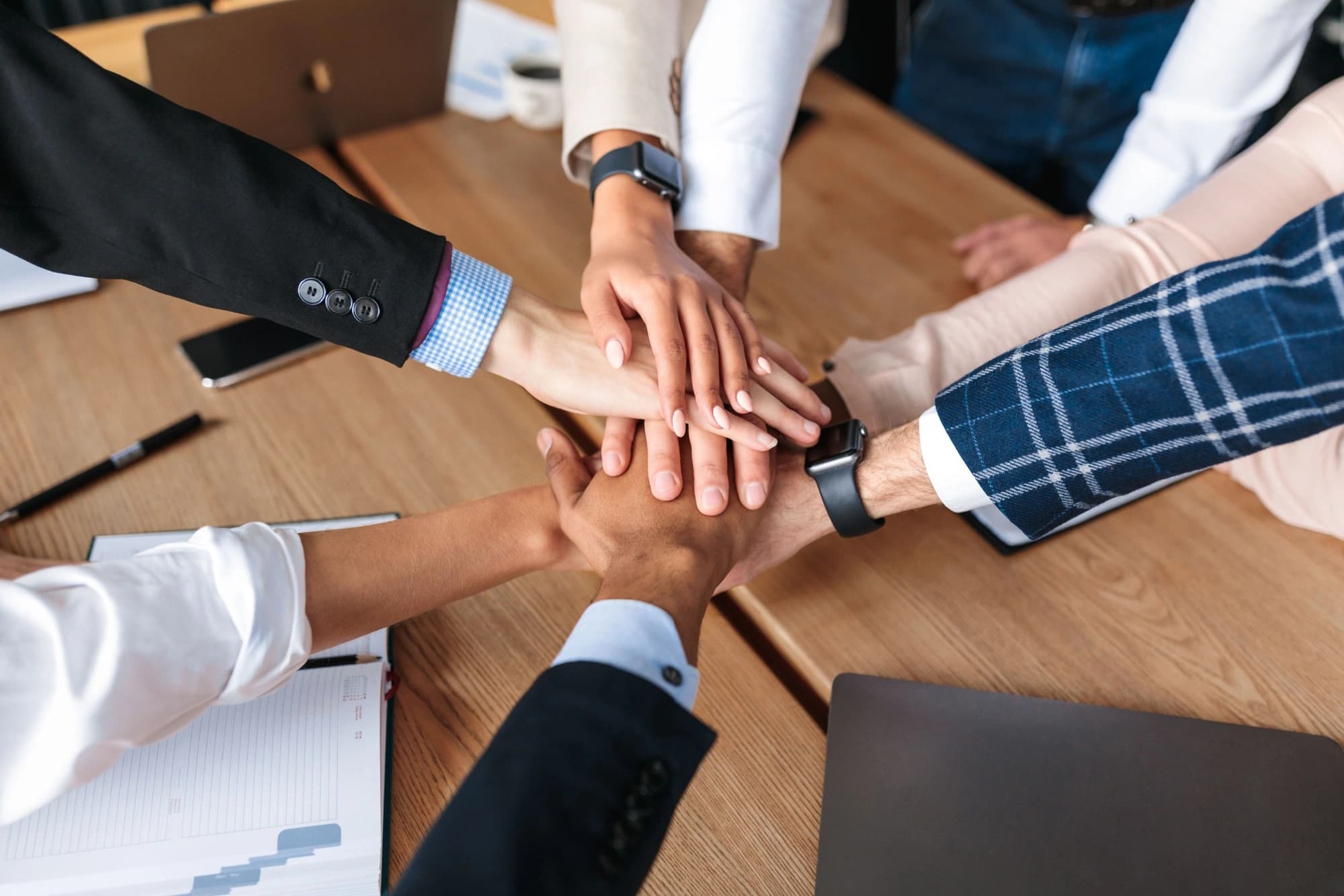Group of business people stacking their hands together