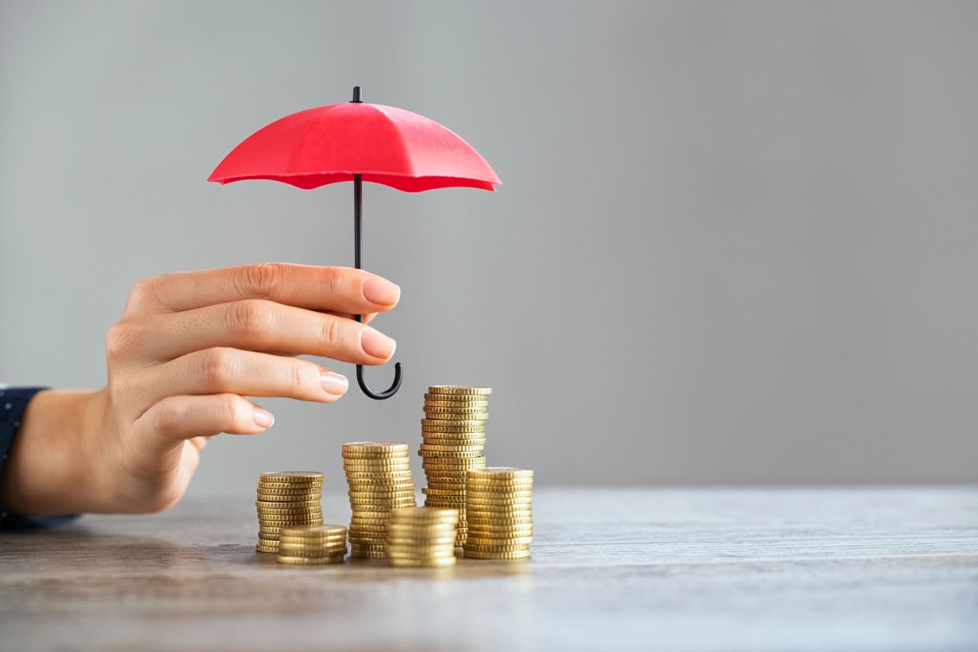 Red umbrella covering a stack of coins