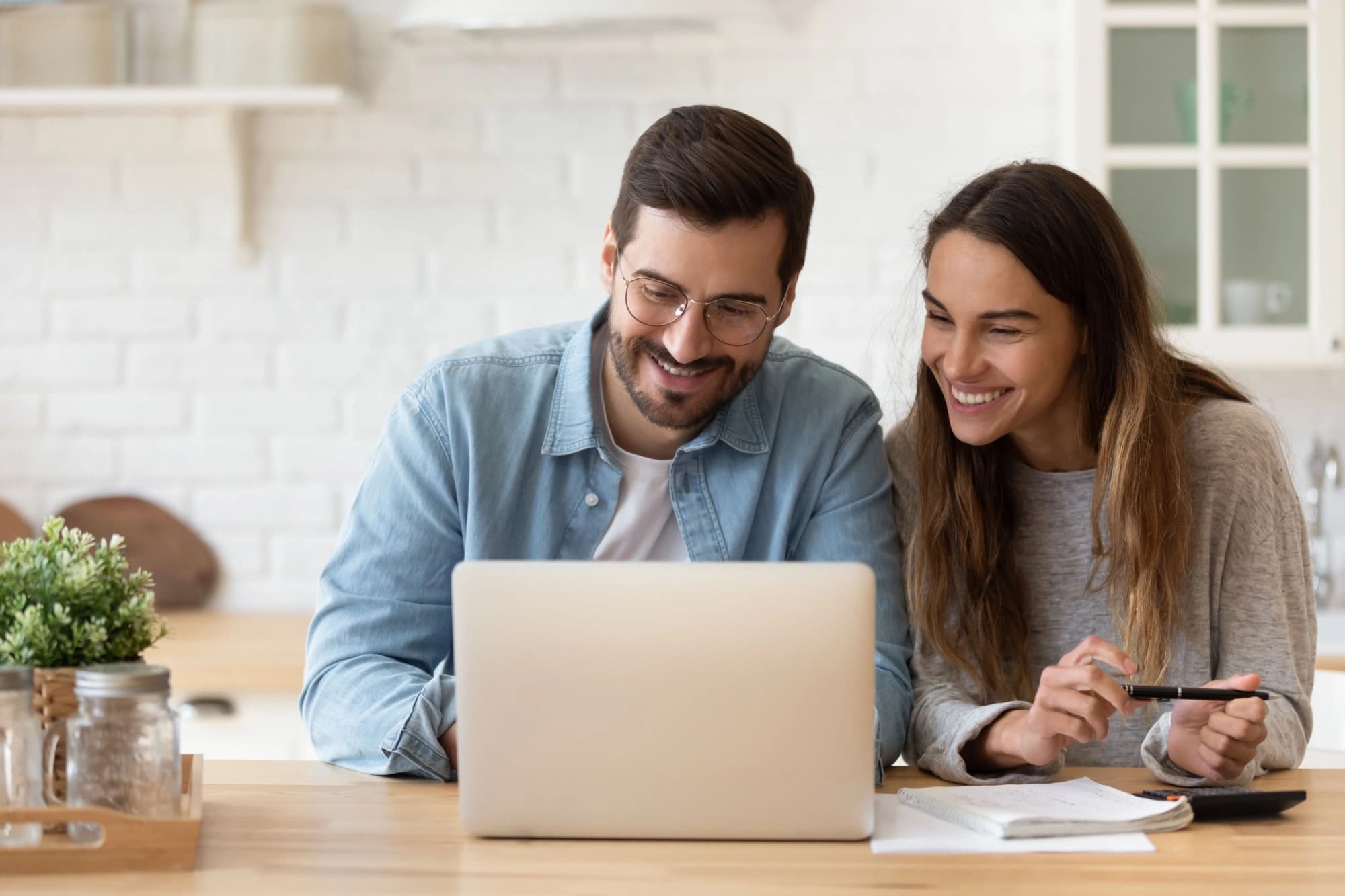 Young couple looking at a laptop while discussing their intra-family loan