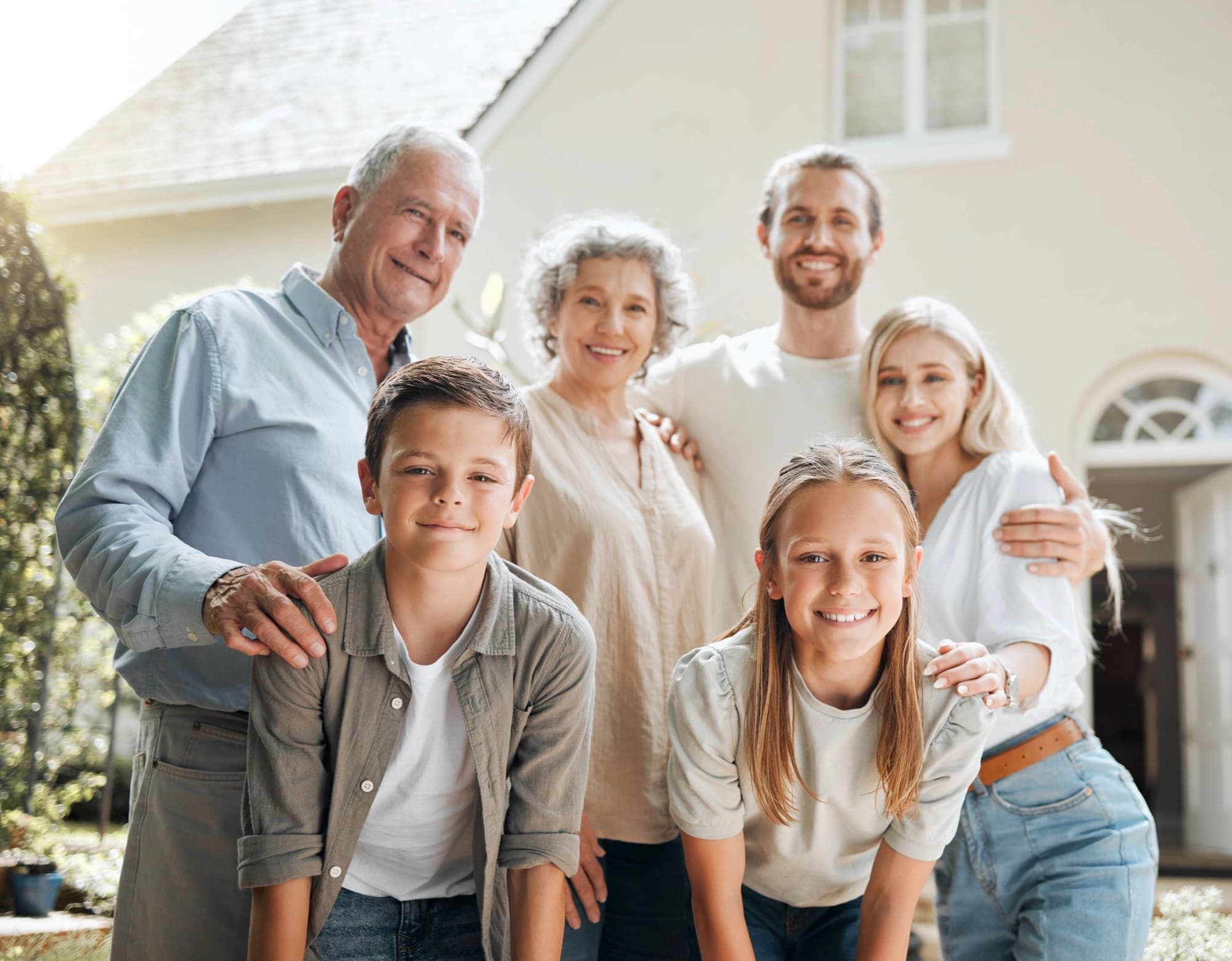 Multigenerational family posing in front of their mansion