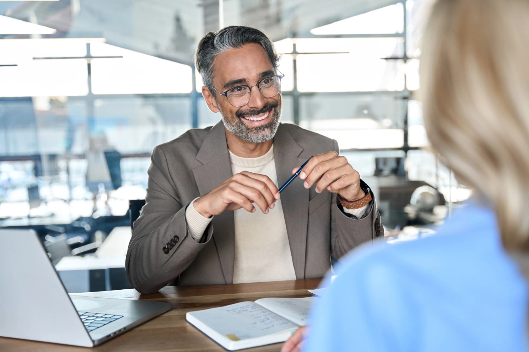 Happy middle-aged financial advisor smiling at his client