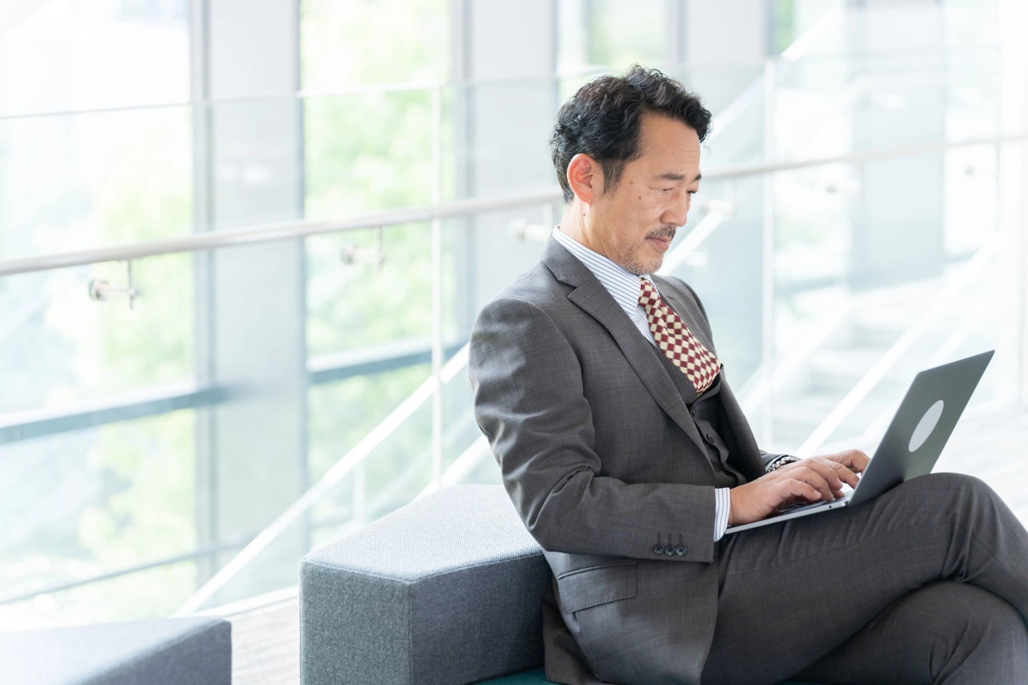 Asian businessman checking his wealth preservation plan on his laptop