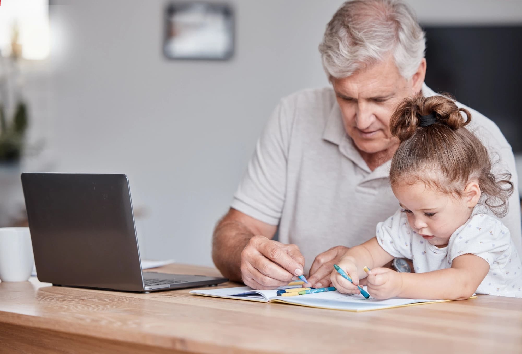 Grandfather coloring with his young granddaughter