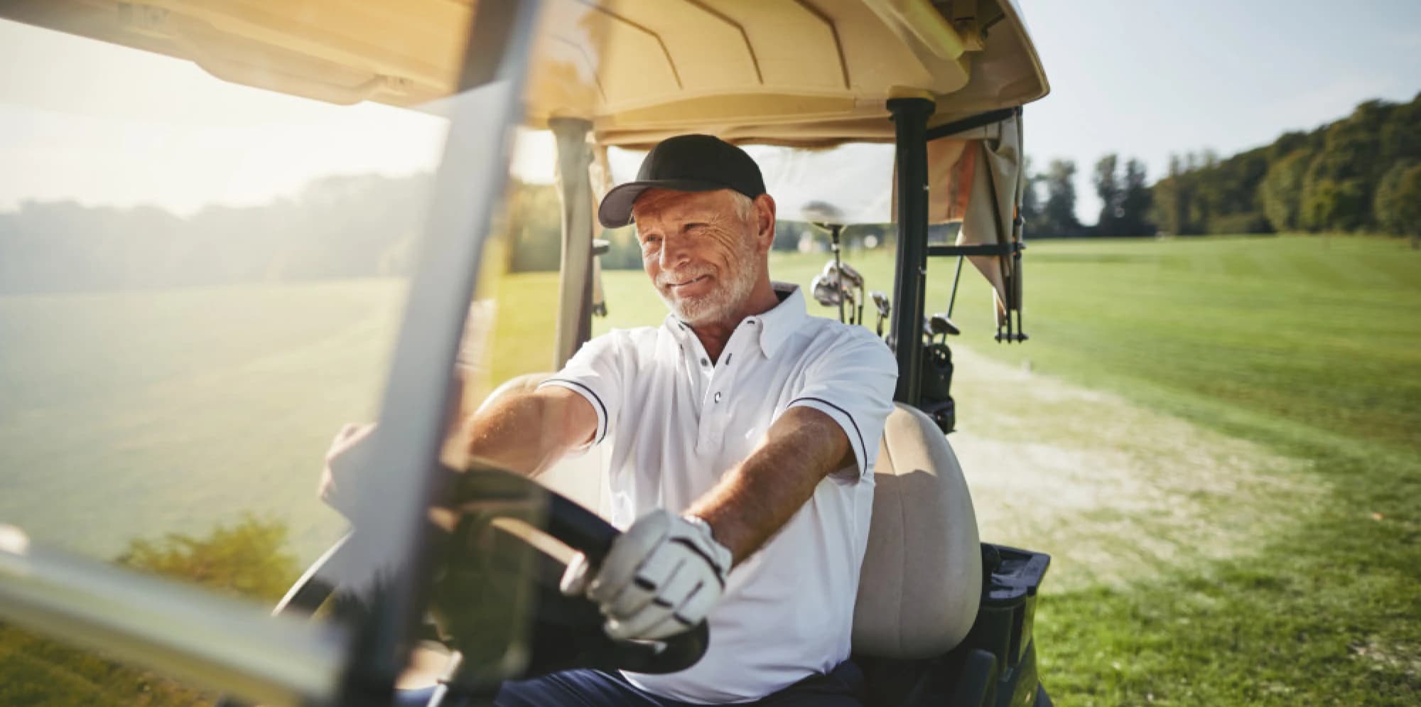 Senior man driving a golf cart around a Houston golf course